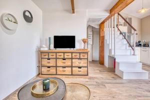 a living room with a tv on top of a dresser at Le Refuge des Vignes in Lamonzie-Saint-Martin