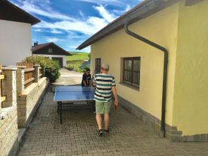 a man standing in front of a ping pong table at Haus Peschl Fewo 2 in Neureichenau