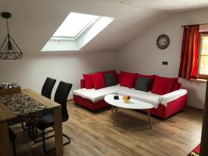 a living room with a red couch and a table at Haus Peschl Fewo 2 in Neureichenau