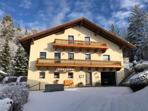 a house with a balcony in the snow at Haus Peschl Fewo 2 in Neureichenau
