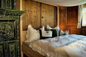 a bed in a room with wooden walls at Widum Obernberg Nikolaus Bergsuite in Obernberg am Brenner