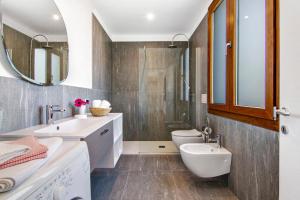 a bathroom with a sink and a toilet and a mirror at Casa vacanza Guattini in Cremia +24 photos