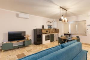 a living room with a blue couch and a kitchen at Borgo Ariano near Volterra by PosarelliVillas in Volterra