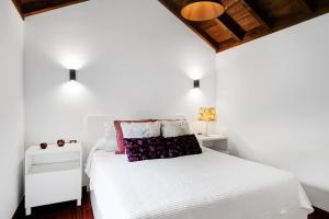 a bedroom with a white bed and two night stands at El Portillo 2 in Buenavista del Norte