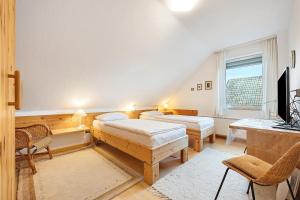 a bedroom with two beds and a television in it at Haus Erna am Deister in Barsinghausen