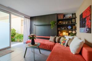 a living room with a red couch and a table at Des vacances de rêve à Mandelieu in Mandelieu-La Napoule