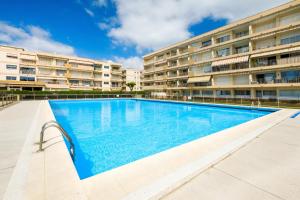 a large swimming pool in front of a building at Des vacances de rêve à Mandelieu in Mandelieu-La Napoule
