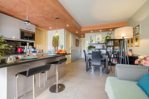 a kitchen and living room with a bar and chairs at Des vacances de rêve à Mandelieu in Mandelieu-La Napoule