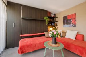 a bedroom with a red bed and a vase of flowers on a table at Des vacances de rêve à Mandelieu in Mandelieu-La Napoule +19 photos
