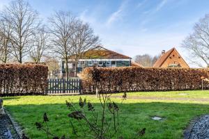 a house with a hedge in front of a yard at Ferienwohnung Moin in Schönwalde am Bungsberg