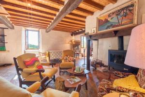 a living room with chairs and a fireplace at Maison de vacances La Toumet in Malabat