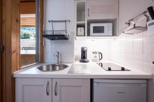 a kitchen with a sink and a microwave at Studio Grand Chalet in Brides-les-Bains +12 photos
