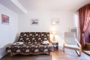 a living room with a couch and a chair at Studio Grand Chalet in Brides-les-Bains