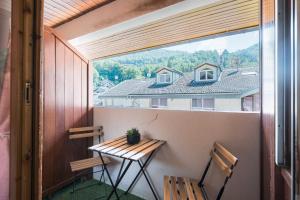a balcony with a table and two chairs and a window at Studio Grand Chalet in Brides-les-Bains