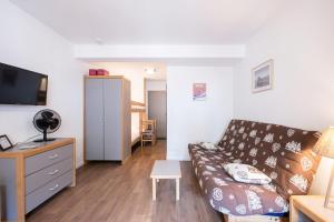 a living room with a couch and a table at Studio Grand Chalet in Brides-les-Bains