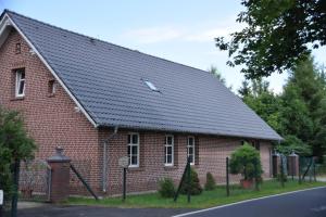 a red brick house with a black roof at Ferienwohnung Eulenhof in Templin +9 photos
