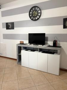 a desk with a tv and a clock on a wall at Casa Domus Oppiorum in Ca degli Oppi