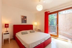 a bedroom with a red bed and a window at Jolie Maison Proche Plage in Toulon +32 photos