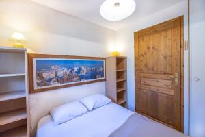 a bedroom with a bed and a wooden door at Le jardin des neiges in Praz-sur-Arly