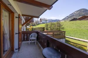 a balcony with a chair and a view of a field at Le jardin des neiges in Praz-sur-Arly