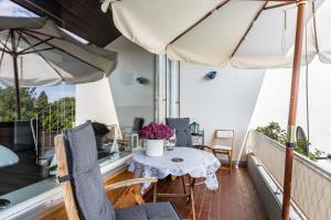 a balcony with a table and two umbrellas at Seesucht in Gaienhofen