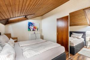 a bedroom with two beds and a wooden ceiling at Seesucht in Gaienhofen
