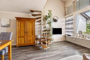 a living room with a spiral staircase and a tv at Seesucht in Gaienhofen