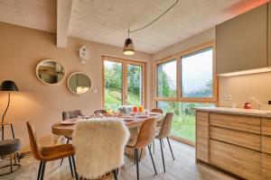 a kitchen and dining room with a table and chairs at L'Ecrin de Venosc piscine privée in Les Deux Alpes