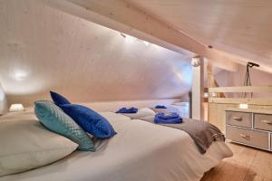 a large bed with blue pillows in a bedroom at L'Ecrin de Venosc piscine privée in Les Deux Alpes +31 photos