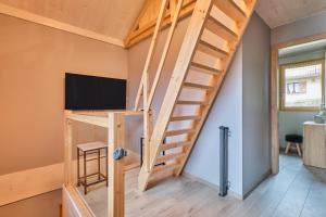 a tiny house with a loft bed and a flat screen tv at L'Ecrin de Venosc piscine privée in Les Deux Alpes