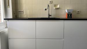 a kitchen with white cabinets and a sink at Haus am Reithagen in Hofgeismar