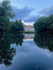 a white building sitting on top of a lake at Haus am Reithagen in Hofgeismar