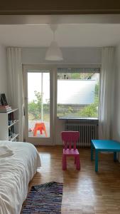 a bedroom with a bed and a bench and a window at Haus am Reithagen in Hofgeismar
