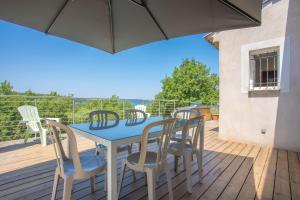 a patio with a blue table and chairs on a deck at Villa Les Brés in Bauduen