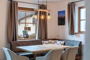 a dining room with a table and chairs and a window at Appartement by Blahut Vacation - og in Ehrwald