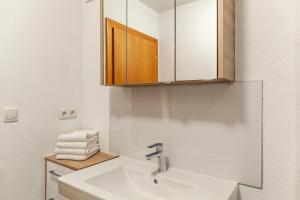 a white bathroom with a sink and a mirror at Appartement by Blahut Vacation - og in Ehrwald +13 photos
