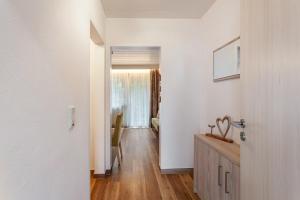 a hallway with white walls and a wooden floor at Landhaus Kramer Meine Cardplus inkl in Willingen +128 photos