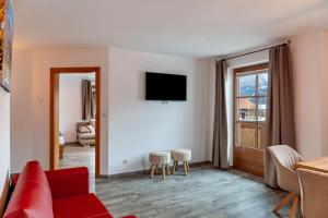 a living room with a couch and a tv on a wall at Appartement by Blahut Vacation - og in Ehrwald