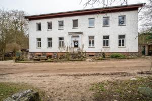 a white house with a dirt road in front of it at Kolbatzer Mühle in Lychen