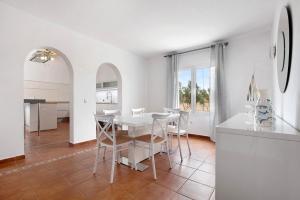 a kitchen and dining room with a white table and chairs at Mayantigo in Juan Gopar