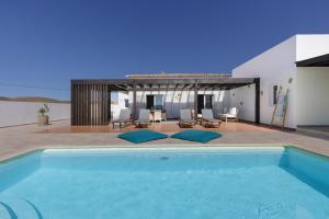 a swimming pool in front of a house at Mayantigo in Juan Gopar
