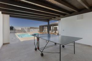a ping pong table in a room with a pool at Mayantigo in Juan Gopar