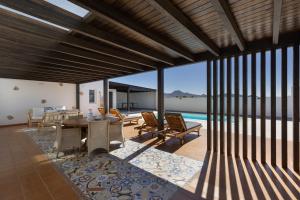 a living room with a table and chairs and a pool at Mayantigo in Juan Gopar