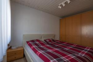 a bedroom with a bed with a plaid blanket at Juttis Bude in Löhnberg