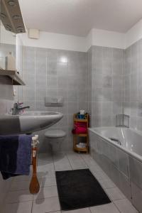 a bathroom with a sink and a tub and a toilet at Juttis Bude in Löhnberg +5 photos