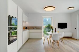 a kitchen and dining room with a table and chairs at Haus Weinblick Apt 5 in Magrè allʼ Adige +18 photos