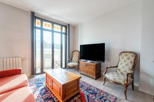 a living room with a couch and a tv at Annecy - Le 10 in Annecy
