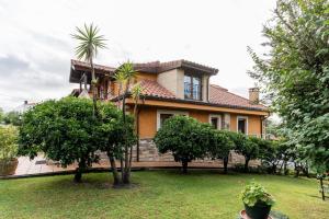 a house with palm trees in front of it at Hosteria Las Fuentes in Rubayo