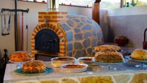 a table with pies and cakes and a stone oven at Hosteria Las Fuentes in Rubayo