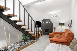 a living room with a staircase and orange couch at Oramas Secret Cellar – Casa Rural in Arico